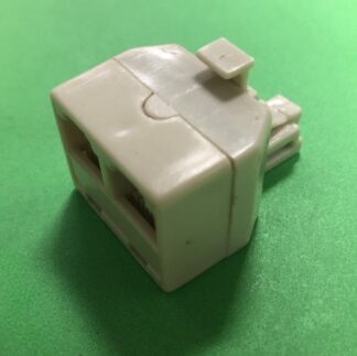 A white connector sitting on top of a green table.